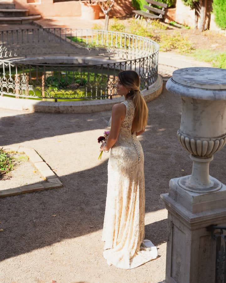Invitada de espaldas con vestido largo de lentejuelas y espalda abierta en un jardín