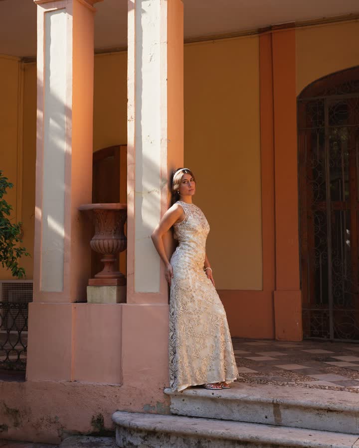 Invitada con vestido de lentejuelas champán apoyada en una columna de un pórtico