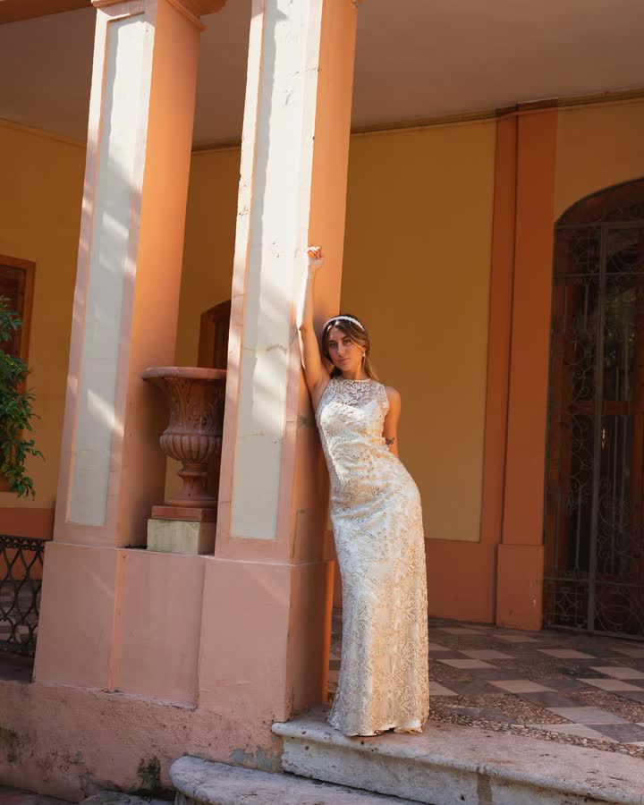 Vestido de fiesta largo de lentejuelas champán en un pórtico de muros anaranjados
